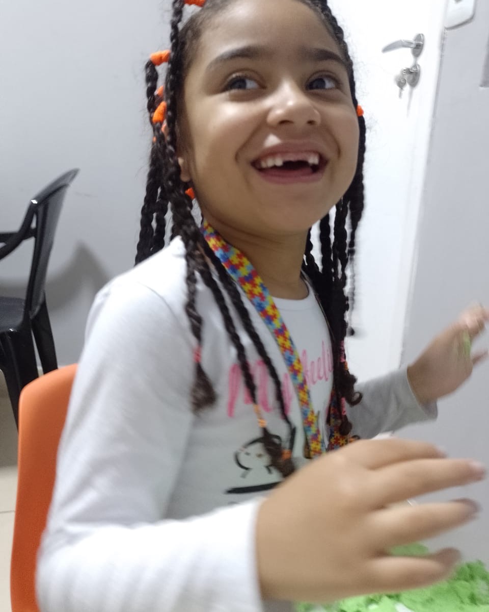Criança sorrindo durante uma atividade no atendimento